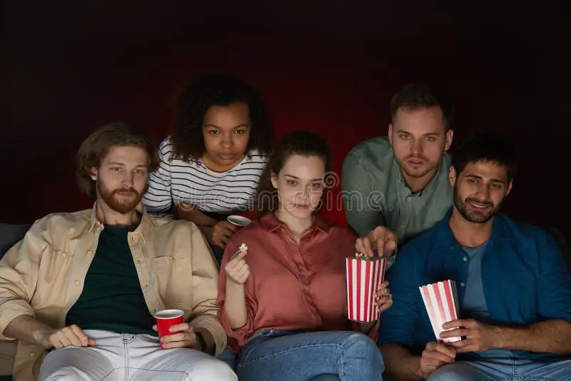 Menonton Film Bersama Teman Sebuah gambar yang menampilkan beragam orang menonton film bersama-sama